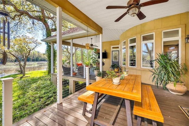 sunroom / solarium with a water view, vaulted ceiling, and ceiling fan