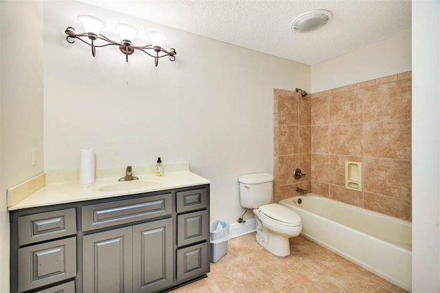 full bathroom with vanity, tile patterned floors, tiled shower / bath combo, toilet, and a textured ceiling