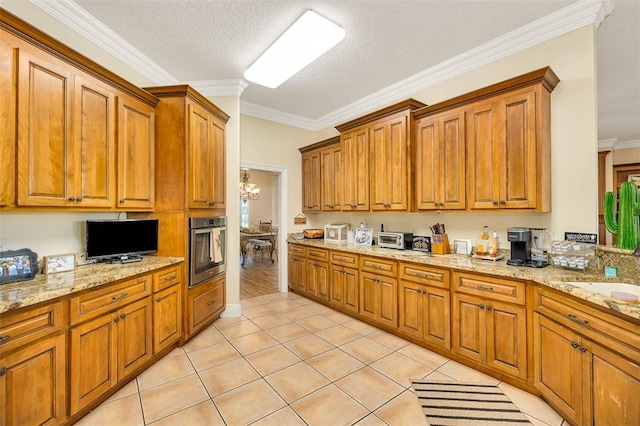 kitchen featuring a chandelier, a textured ceiling, crown molding, and stainless steel oven