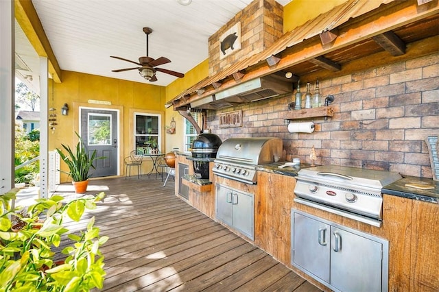 view of patio / terrace featuring grilling area, ceiling fan, a wooden deck, and exterior kitchen