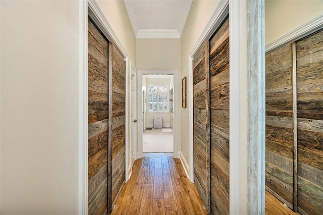 hall featuring crown molding and light hardwood / wood-style flooring