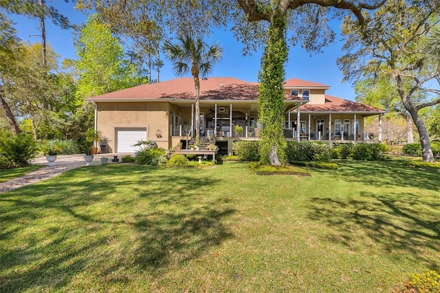 view of front of house featuring covered porch, a garage, and a front yard