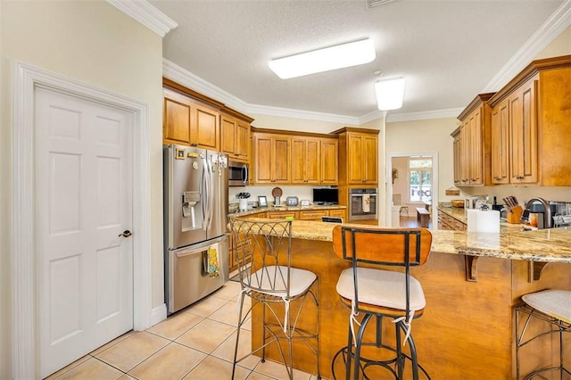 kitchen featuring a kitchen breakfast bar, light stone counters, crown molding, and appliances with stainless steel finishes