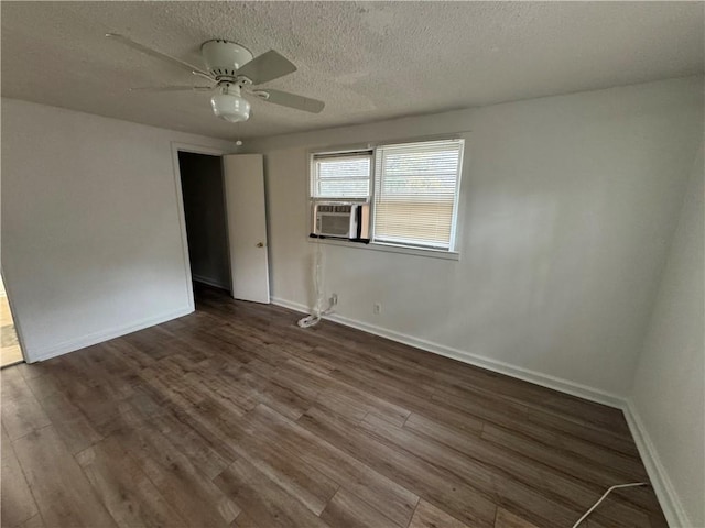 spare room featuring cooling unit, a textured ceiling, ceiling fan, and dark hardwood / wood-style floors