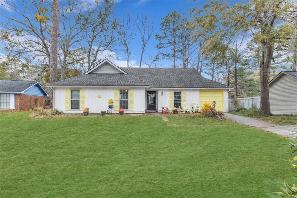 ranch-style house featuring a garage and a front yard