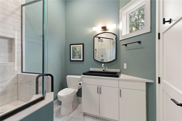 bathroom featuring vanity, toilet, and a shower with shower door