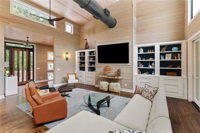 living room with a healthy amount of sunlight, dark hardwood / wood-style flooring, and high vaulted ceiling