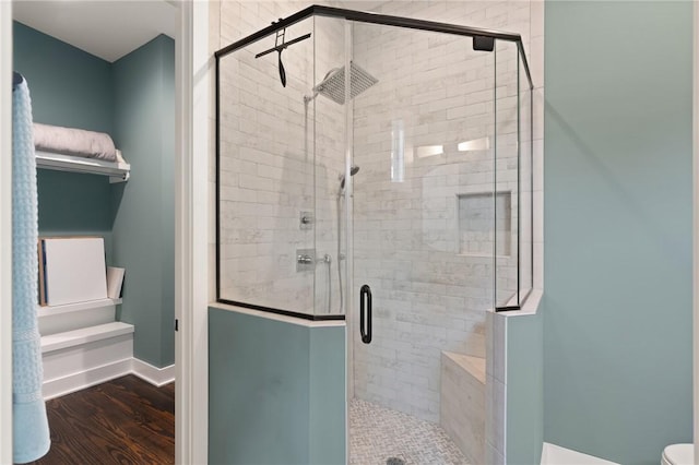 bathroom with a shower with door and hardwood / wood-style flooring