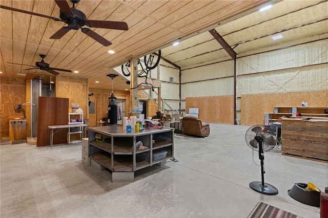 interior space featuring ceiling fan and wood walls