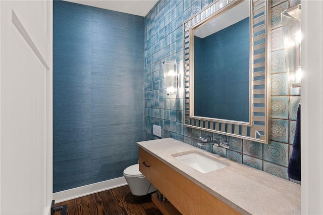 bathroom featuring backsplash, vanity, tile walls, hardwood / wood-style floors, and toilet