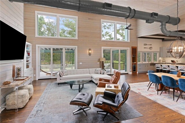 living room featuring a wealth of natural light, wooden walls, and a high ceiling