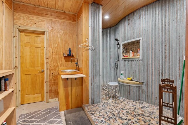 bathroom with concrete flooring, wood walls, and wooden ceiling