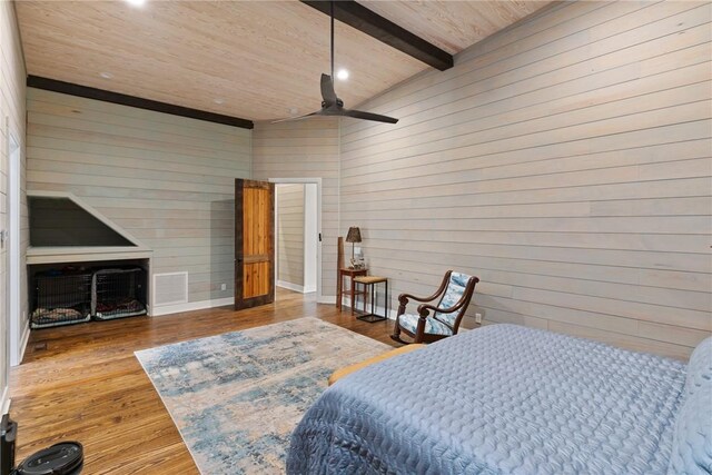 bedroom featuring wood-type flooring, vaulted ceiling with beams, ceiling fan, and wood walls