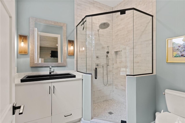 bathroom with walk in shower, vanity, and toilet