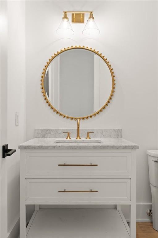 bathroom with vanity, baseboards, and toilet
