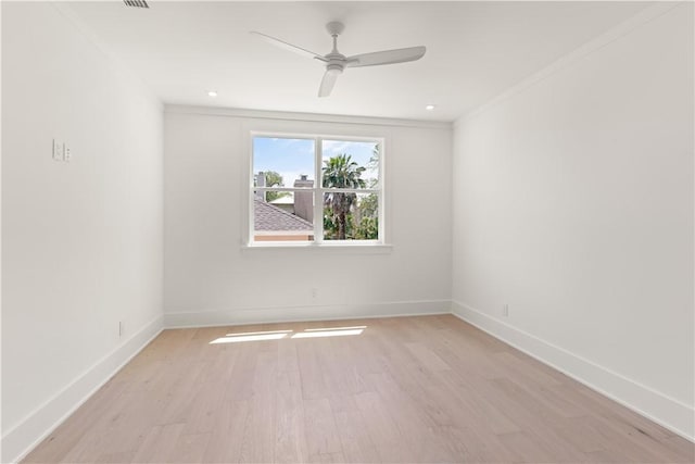 spare room with baseboards, ornamental molding, a ceiling fan, and light wood-style flooring