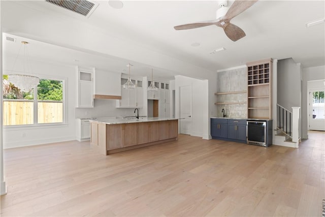 kitchen featuring a wealth of natural light, light wood-style flooring, white cabinetry, and visible vents