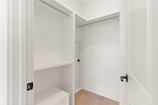 walk in closet with light wood-style flooring