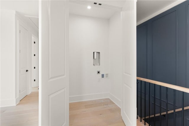 interior space featuring hookup for an electric dryer, laundry area, baseboards, light wood finished floors, and hookup for a washing machine