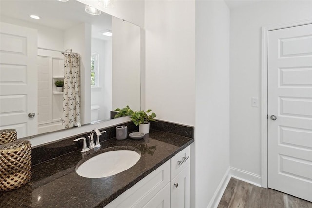 bathroom featuring hardwood / wood-style floors, vanity, and curtained shower