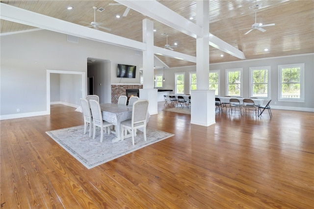 dining room featuring beam ceiling, light hardwood / wood-style floors, high vaulted ceiling, and wooden ceiling