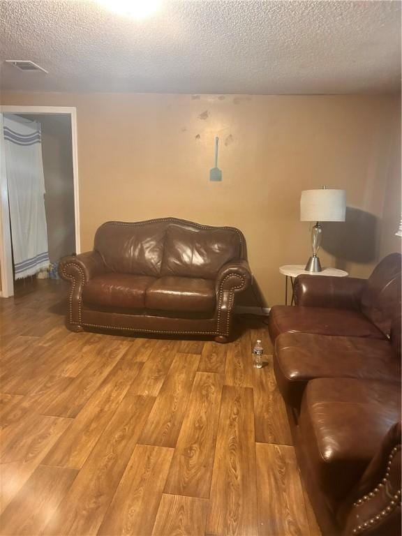 living room featuring light hardwood / wood-style floors and a textured ceiling