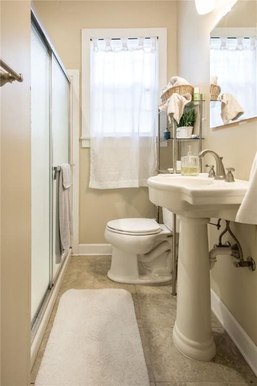 bathroom with tile patterned flooring, toilet, and walk in shower