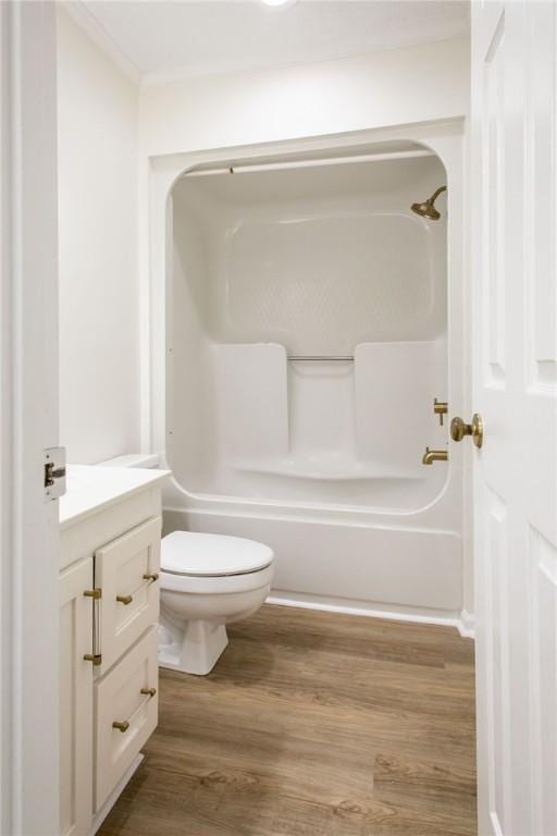 full bathroom featuring vanity, crown molding, toilet, hardwood / wood-style flooring, and bathtub / shower combination