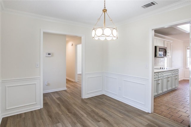 unfurnished dining area featuring crown molding and dark hardwood / wood-style floors