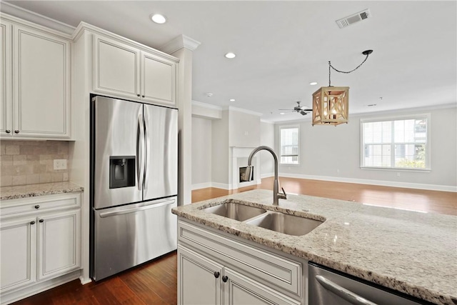 105 Gascoigne Ave Unit 204, Saint Simons Island, GA 31522 - kitchen with appliances with stainless steel finishes, ornamental molding, dark wood-style floors, tasteful backsplash, and light stone countertops