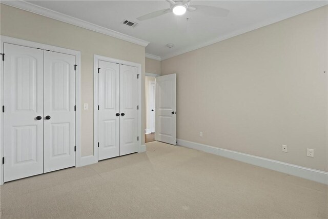 105 Gascoigne Ave Unit 204, Saint Simons Island, GA 31522 - unfurnished bedroom with light colored carpet, multiple closets, crown molding, and a ceiling fan