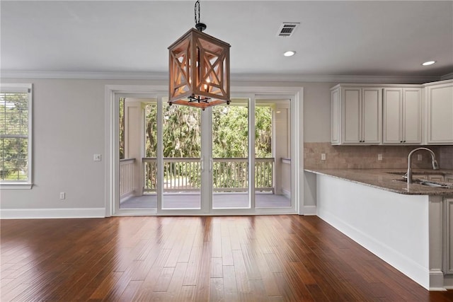 105 Gascoigne Ave Unit 204, Saint Simons Island, GA 31522 - unfurnished dining area with dark wood-style flooring, crown molding, and recessed lighting