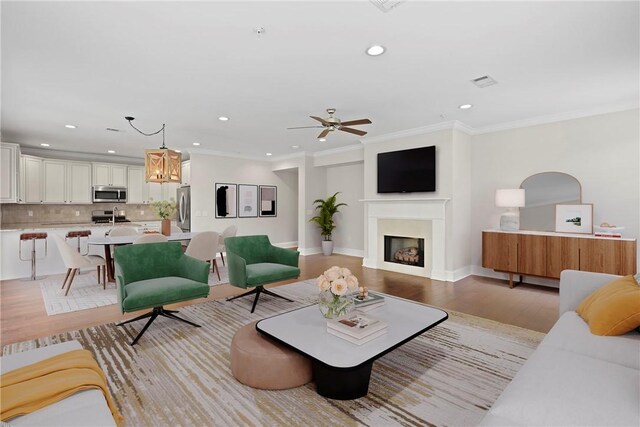 105 Gascoigne Ave Unit 204, Saint Simons Island, GA 31522 - living room featuring recessed lighting, a fireplace, light wood-style floors, a ceiling fan, and ornamental molding