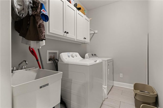 washroom featuring cabinets, separate washer and dryer, and sink