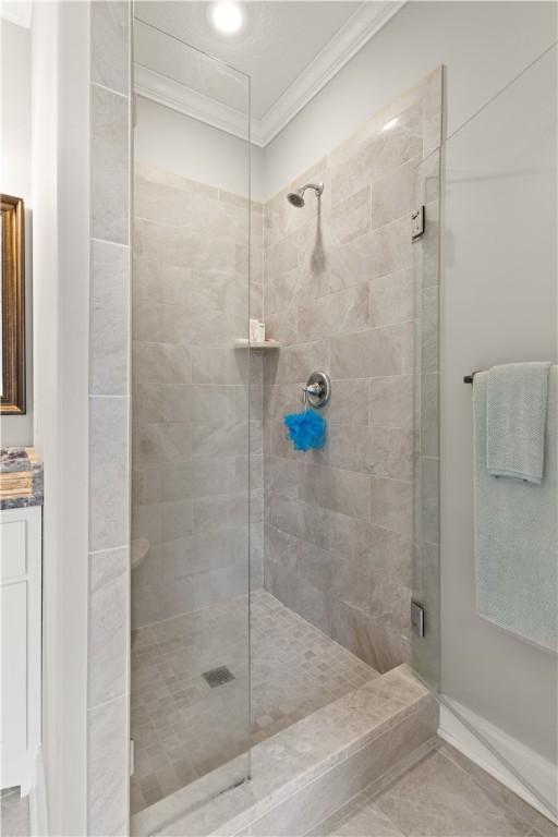 bathroom featuring vanity, tile patterned floors, an enclosed shower, and crown molding