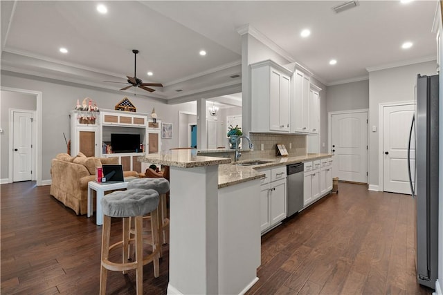 kitchen featuring white cabinetry, sink, ceiling fan, light stone counters, and appliances with stainless steel finishes