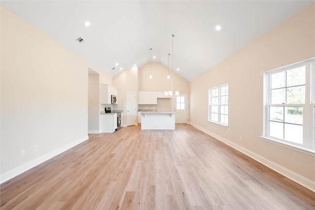 unfurnished living room with light wood-style floors, visible vents, high vaulted ceiling, and baseboards