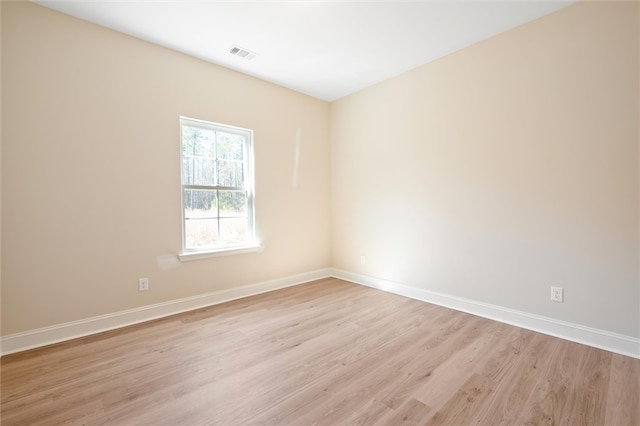 spare room with baseboards, visible vents, and light wood-style floors