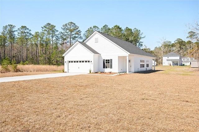 view of front of house featuring concrete driveway, an attached garage, and a front lawn