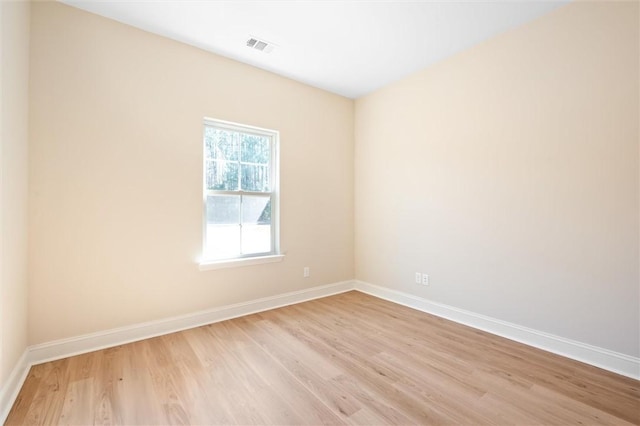 spare room featuring baseboards, visible vents, and light wood-style floors