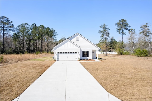 view of front of house with an attached garage, concrete driveway, and a front yard