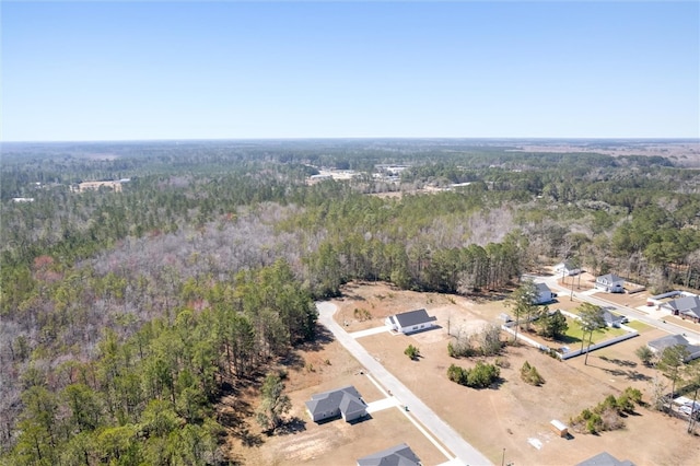 birds eye view of property featuring a wooded view