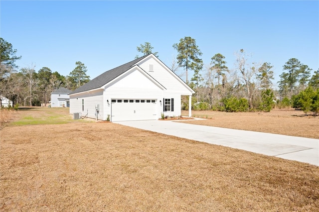 view of side of property with a yard, central AC, driveway, and a garage