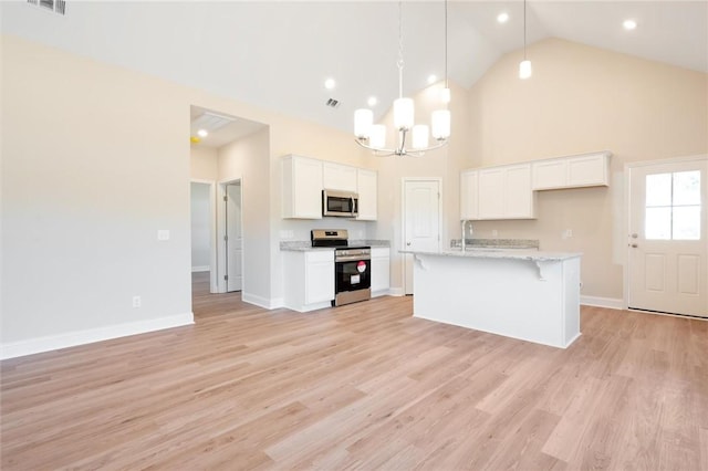 kitchen featuring a breakfast bar area, light wood finished floors, an inviting chandelier, appliances with stainless steel finishes, and white cabinets