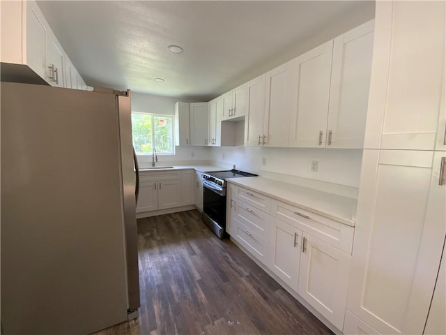 201 Washington Ave, Waycross, GA 31503 - kitchen featuring stainless steel appliances, dark wood finished floors, white cabinets, and a sink
