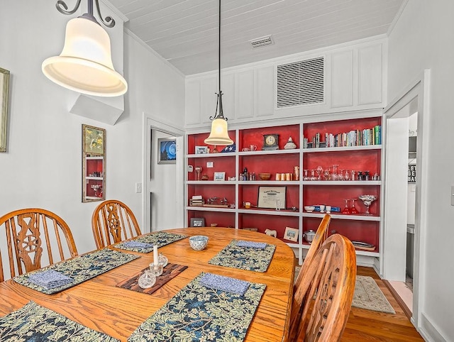 dining area with crown molding and hardwood / wood-style floors