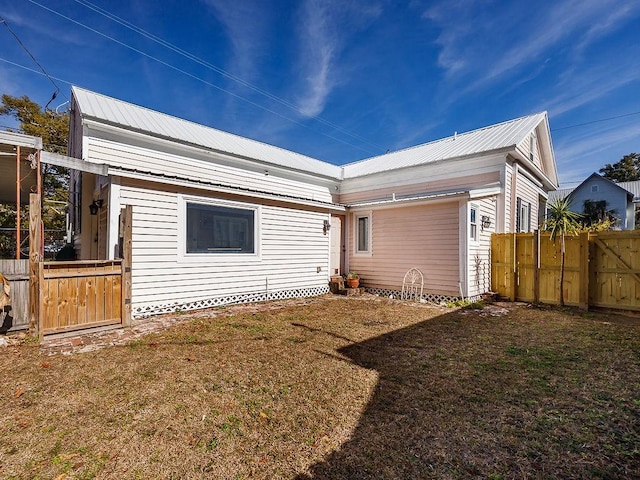 back of house with a lawn