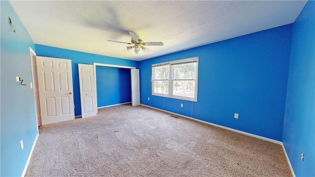 unfurnished bedroom featuring light colored carpet and ceiling fan