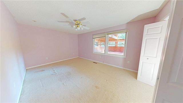 carpeted empty room featuring a textured ceiling and ceiling fan