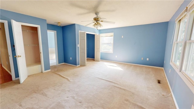 unfurnished bedroom featuring light carpet and ceiling fan